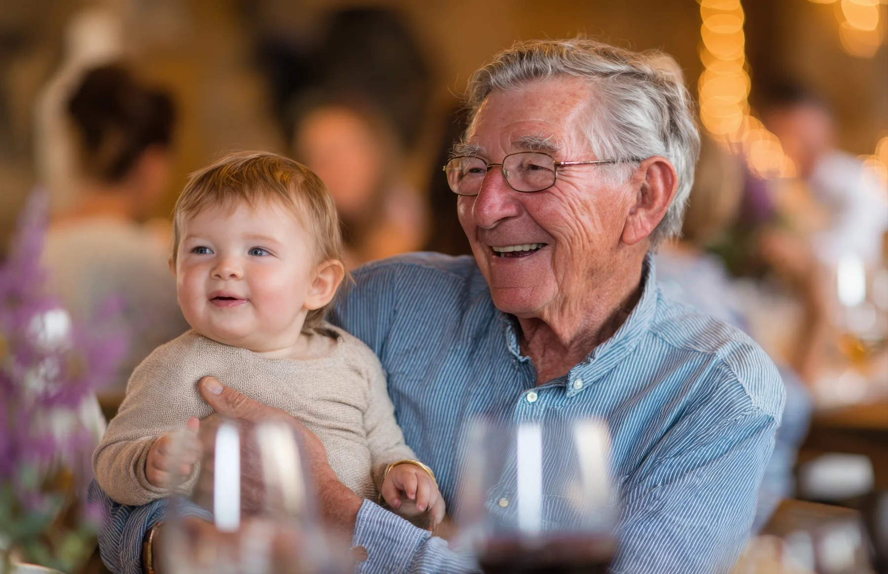 An older man enjoying time with a young child at a family gathering